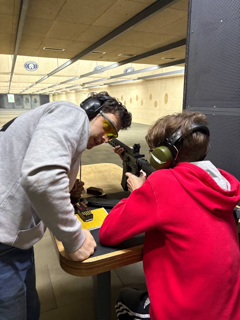 An instructor shows a student the hits on a paper target