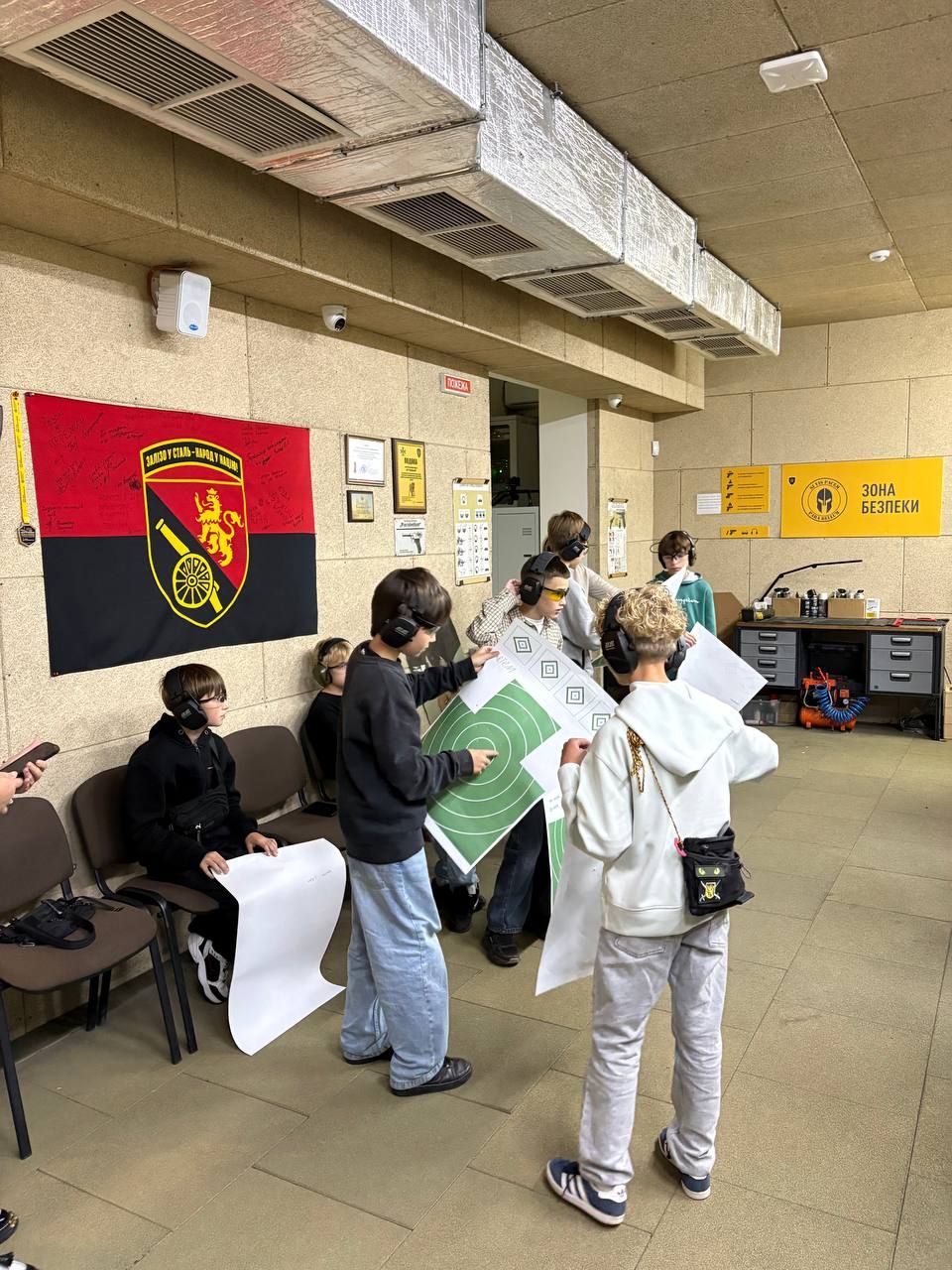 An instructor helps a student take aim at the firing line
